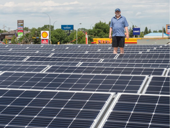 John Brazill, director of large scale solar projects with Wascana Solar Co-operative, stands among solar panels on the roof of the Conexus Credit Union North Albert branch. BRANDON HARDER / Regina Leader-Post